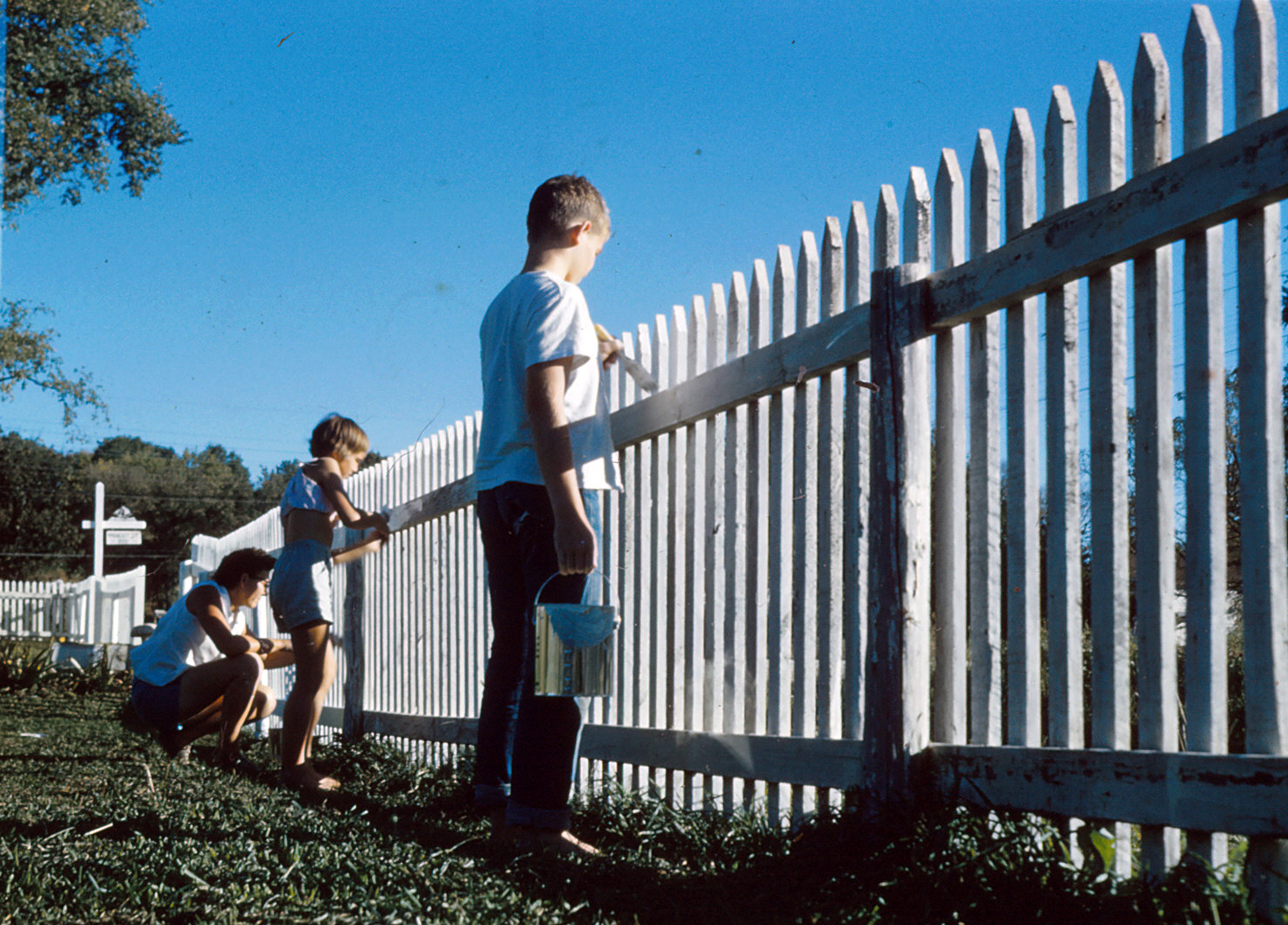 Photo of Mom, Linda and Tony painting the picket fence